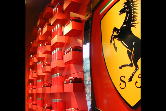 Ferrari showroom display with red shelves and miniature cars.